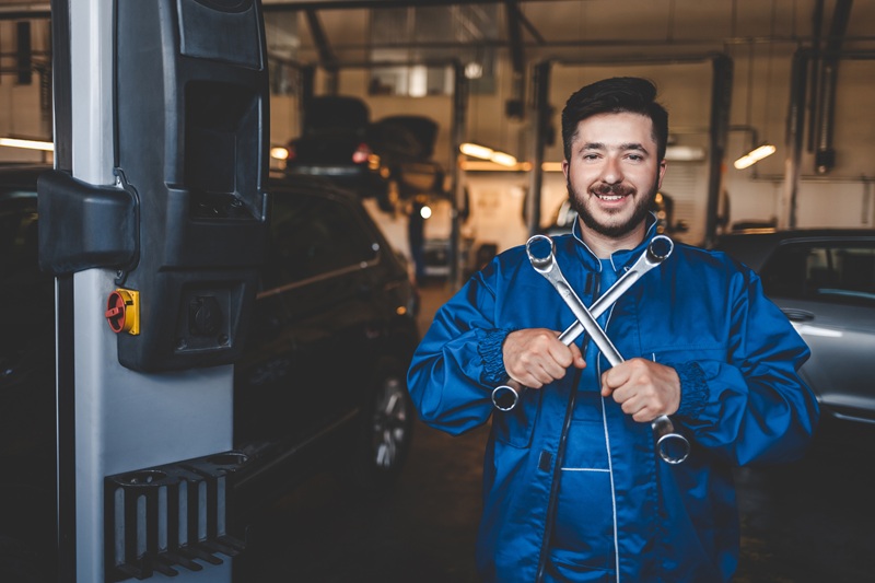 positive auto mechanic stands with wrenches in his 2024 10 18 08 18 15 utc